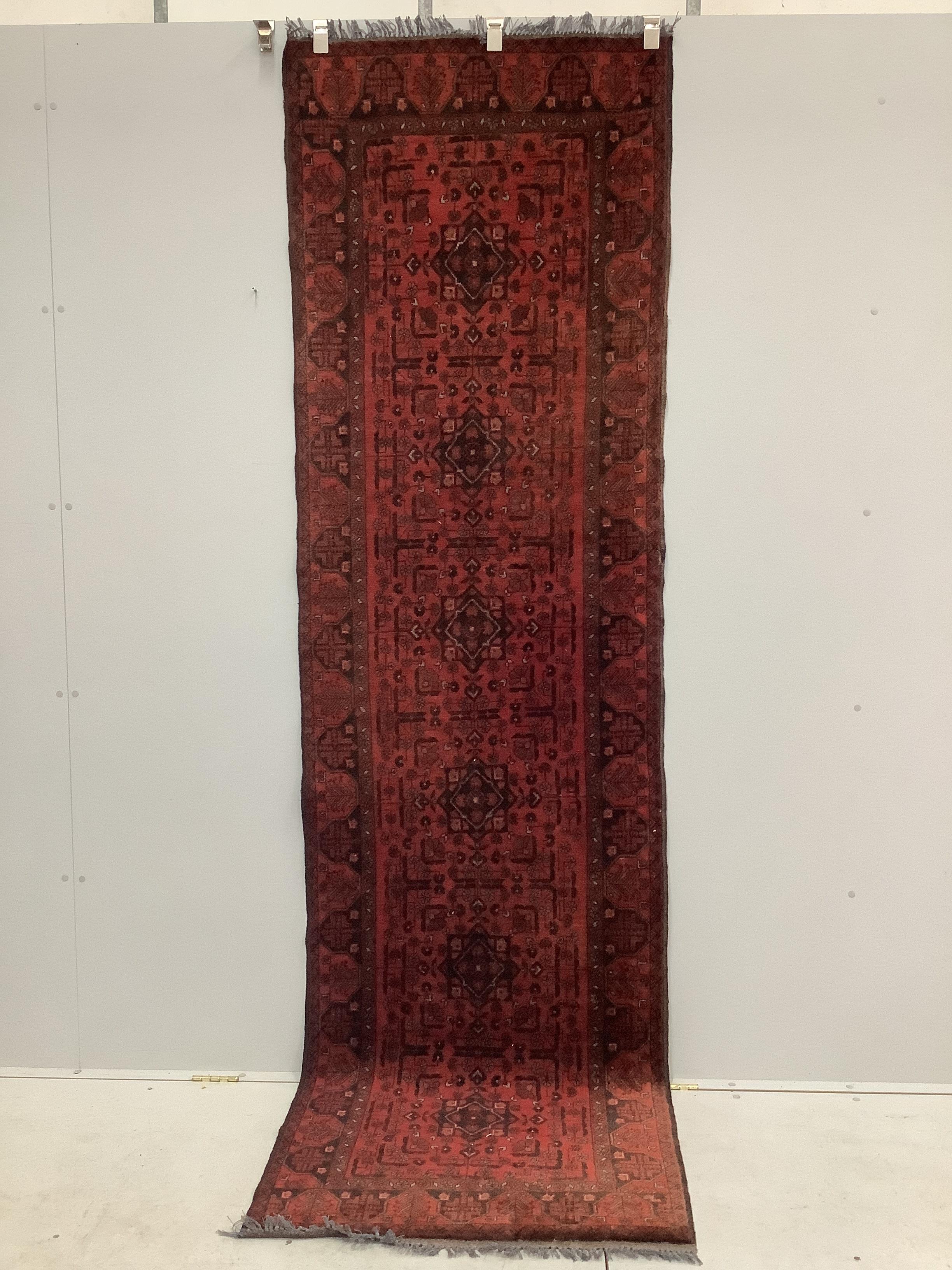 An Afghan red ground runner, 290 x 85cm
